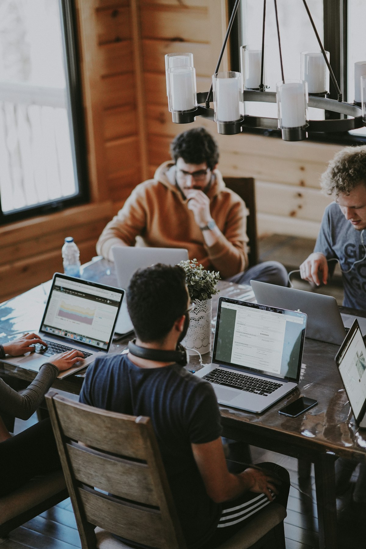 Integrantes del equipo trabajando con notebooks alrededor de una mesa