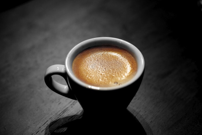 Primer plano de un espresso con crema dorada en taza oscura
