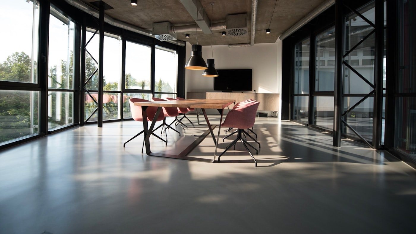 Sala de reuniones con mesa de madera y grandes ventanales