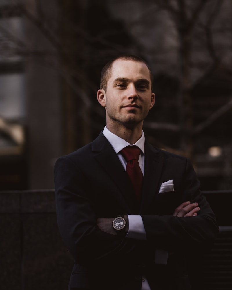 Retrato de un socio de arbitraje, traje oscuro y corbata, en exterior corporativo