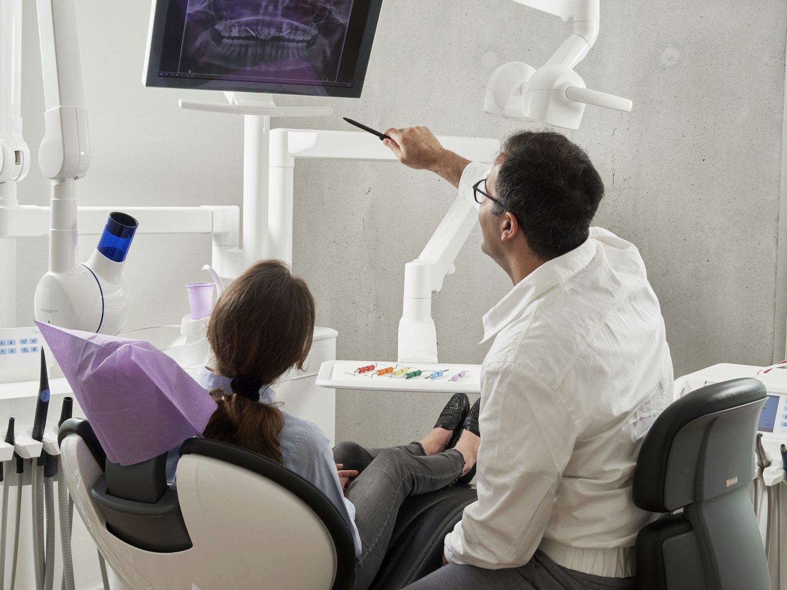 Odontóloga mostrando a una paciente su radiografía dental en el consultorio